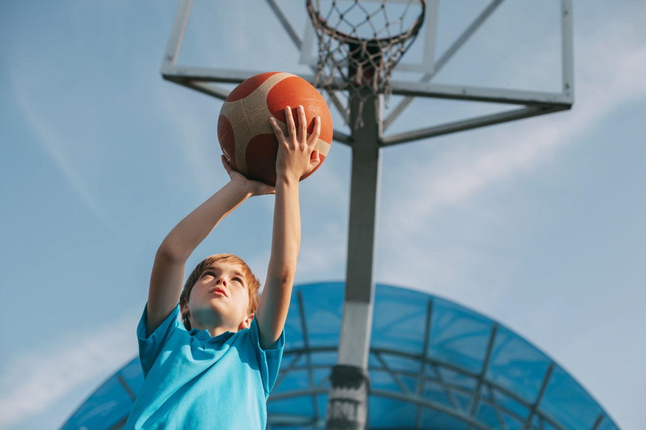 A boy in a sports uniform throws a ball into a bas 2022 11 15 07 04 36 utc